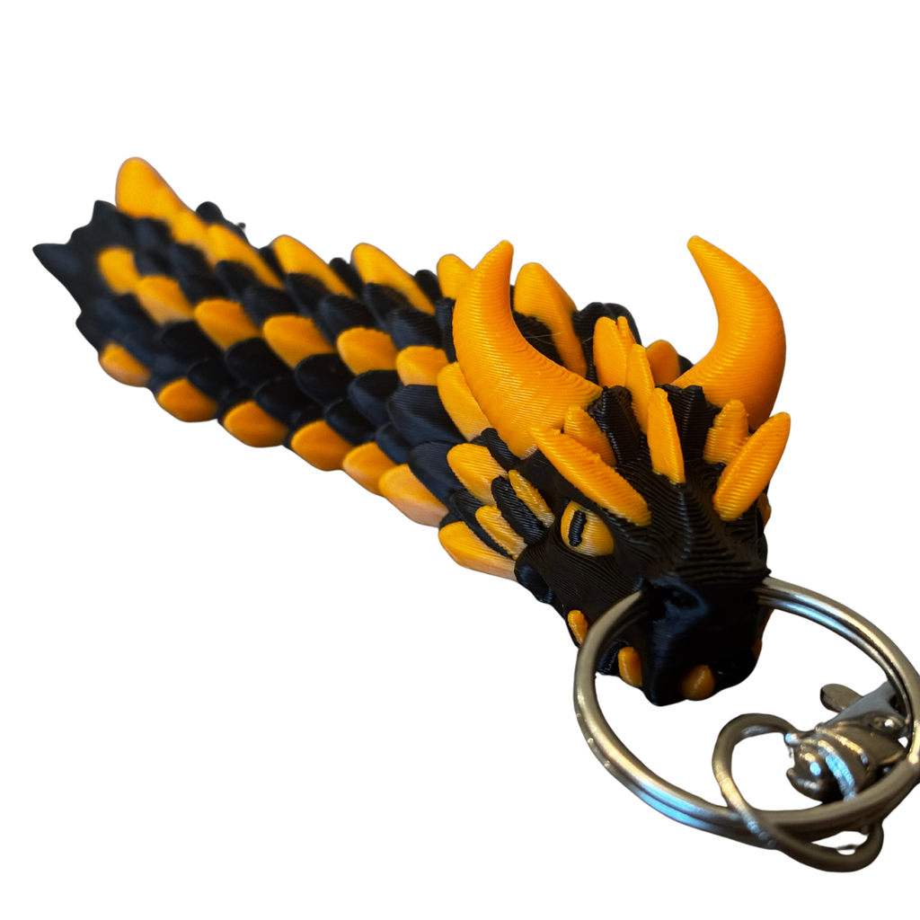 PixelClaw 3D black and orange articulated dragon keychain with detailed 3D-printed scales and horns.